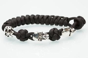 Image showing Black braided bracelet with skulls on white background