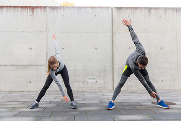 Image showing close up of couple stretching on city street