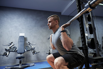 Image showing young man flexing muscles with barbell in gym