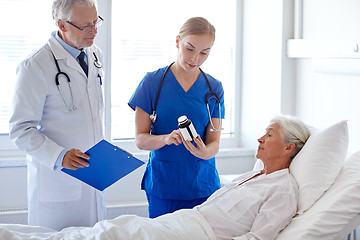 Image showing doctor giving medicine to senior woman at hospital