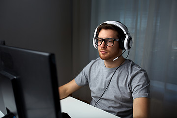 Image showing man in headset playing computer video game at home