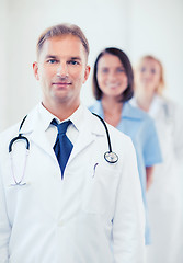 Image showing doctor with stethoscope and colleagues