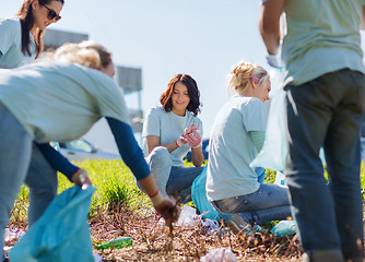 Image showing volunteers with garbage bags cleaning park area