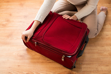 Image showing close up of woman packing travel bag for vacation