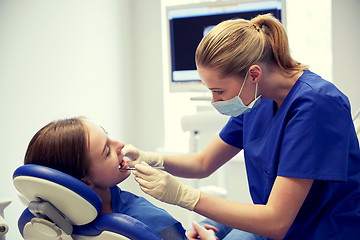 Image showing female dentist checking patient girl teeth