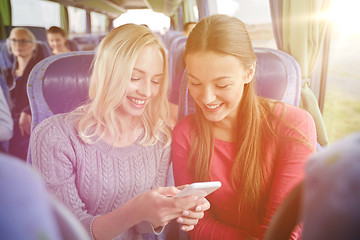 Image showing happy young women in travel bus with smartphone