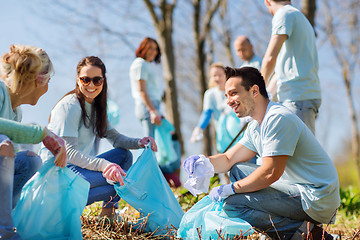 Image showing volunteers with garbage bags cleaning park area