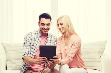 Image showing smiling happy couple with tablet pc at home