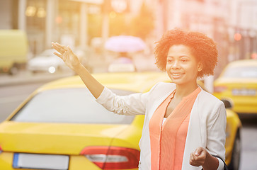 Image showing happy african woman catching taxi