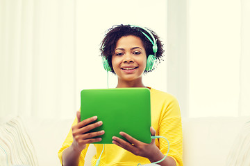 Image showing happy african woman with tablet pc and headphones