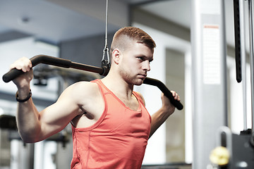 Image showing man flexing muscles on cable machine gym