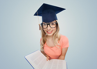 Image showing student woman in mortarboard with encyclopedia