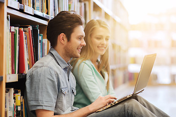 Image showing happy students with laptop in library
