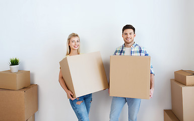 Image showing smiling couple with big boxes moving to new home