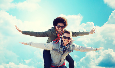 Image showing happy teenage couple in shades having fun outdoors