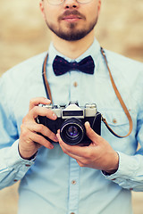 Image showing close up of hipster man with film camera in city