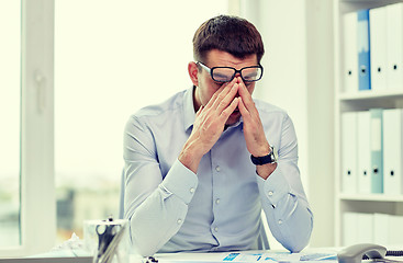 Image showing tired businessman with eyeglasses in office