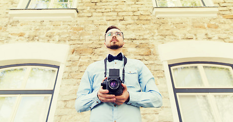 Image showing happy young hipster man with film camera in city