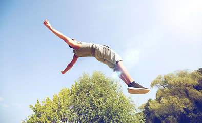 Image showing sporty young man jumping in summer park