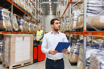 Image showing businessman with clipboard at warehouse