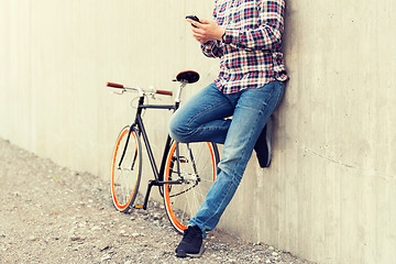 Image showing close up of hipster man with smartphone and bike