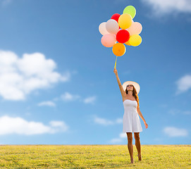 Image showing smiling young woman in sunglasses with balloons