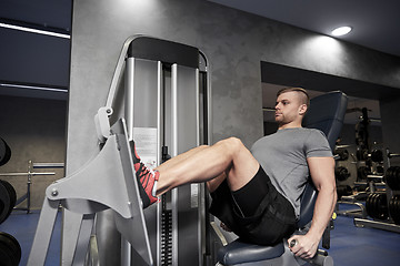 Image showing man flexing leg muscles on gym machine