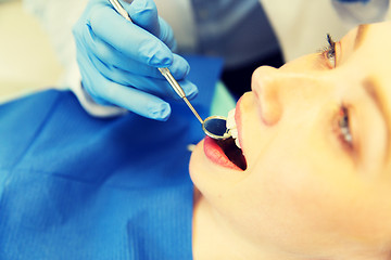 Image showing close up of dentist examining female patient teeth