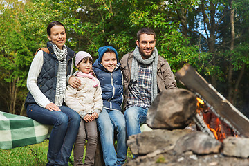 Image showing happy family sitting on bench at camp fire