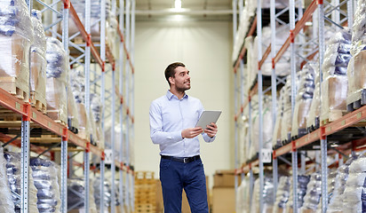 Image showing happy businessman with tablet pc at warehouse