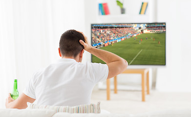 Image showing man watching football or soccer game on tv at home