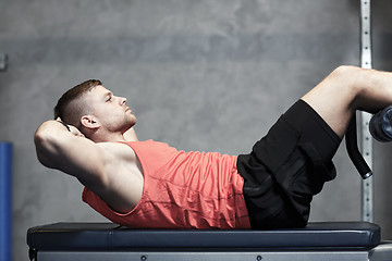 Image showing young man making abdominal exercises in gym