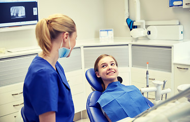 Image showing happy female dentist with patient girl at clinic