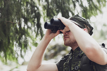 Image showing young soldier or hunter with binocular in forest