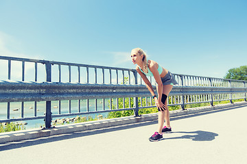 Image showing young woman with injured knee or leg outdoors