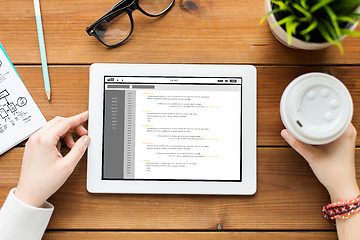 Image showing close up of woman with tablet pc on wooden table