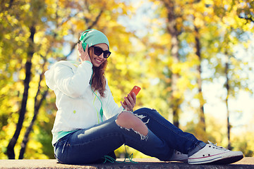 Image showing happy young woman with smartphone and headphones