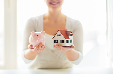 Image showing close up of woman with house model and piggy bank