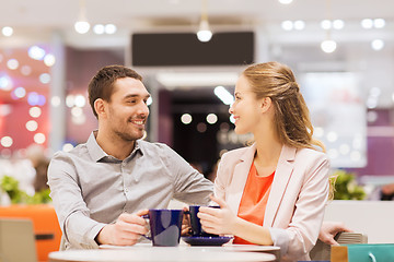 Image showing happy couple with shopping bags drinking coffee