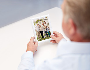 Image showing close up of old man holding happy family photo
