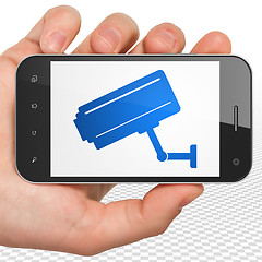 Image showing Safety concept: Hand Holding Smartphone with Cctv Camera on display