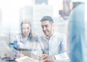 Image showing smiling businesspeople with tablet pc in office