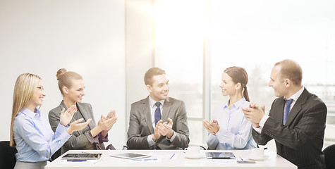 Image showing business team with laptop clapping hands