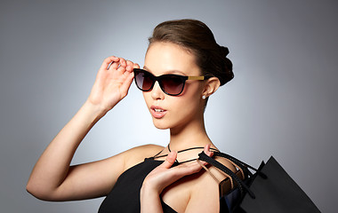 Image showing happy woman in black sunglasses with shopping bags