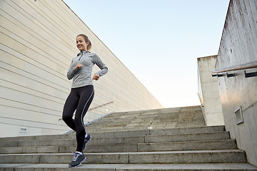 Image showing happy sporty woman running downstairs in city