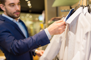 Image showing close up of man choosing shirt in clothing store