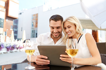 Image showing happy couple with tablet pc at restaurant terrace