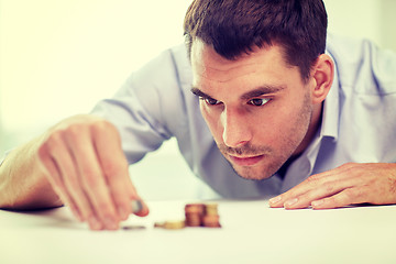 Image showing businessman with coins at office