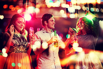 Image showing smiling friends with wine glasses and beer in club