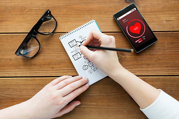 Image showing close up of woman or student writing to notepad